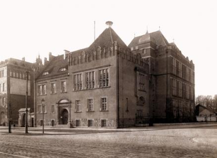 Czarnobiała fotografia przedstawiająca duży, ozdobny, stary budynek będący do 1945 roku siedzibą Archiwum Państwowego we Wrocławiu, zniszczony podczas Drugiej Wojny Światowej