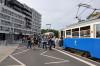 Podjeżdzający tramwaj i grupa ludzi