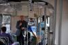 Grupa ludzi we wnętrzu tramwaju i przemawiający mężczyzna
