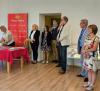 Mężczyźni i kobiety stojący w sali wystawowej. Są to uczestnicy wydarzenia.