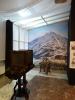 Jedna z sal muzealnych udająca atelier fotograficzne ze starym aparatem, ścianką z dużą reprodukcją dawnej fotografii góry Śnieżka w Karkonoszach. Przed ścianką stoi stare drewniane krzesło dla osoby fotografowanej.